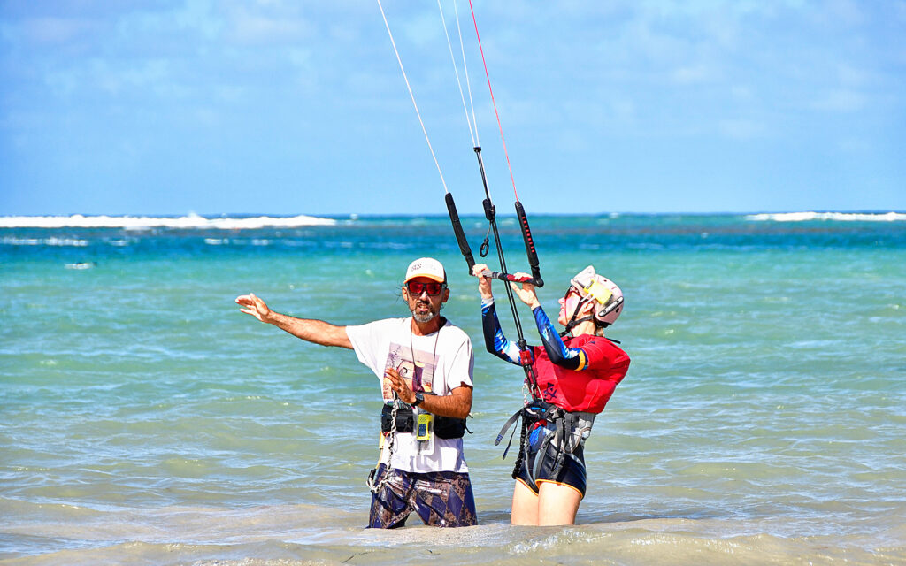 experienced kitesurfing instructor explaining exercices to his student