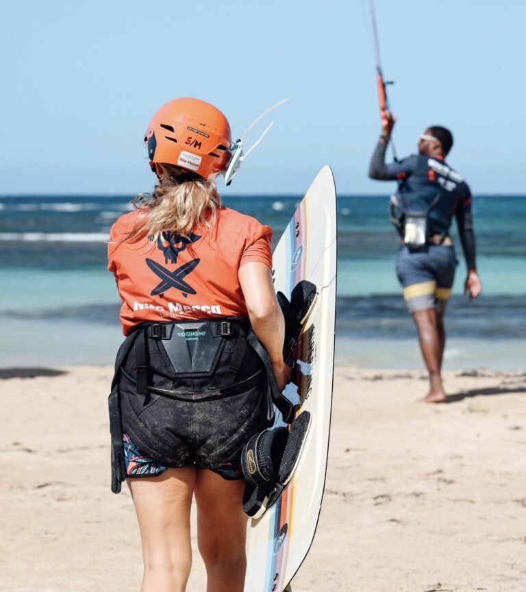 Kitesurfing Lessons for Beginners 17 kitesurfing student with a kiteboard is following its instructor